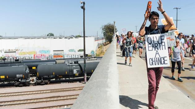 Jules Luna, (R), plays a tambourine while walking in the People's Climate March protest for the environment in the Wilmington neighborhood in Los Angeles, California. While a good-natured mood prevailed and there were no signs of violence, many demonstrators said they were angered by the prospect of Trump carrying through on his vow to roll back protections put in place by his predecessor, Democrat Barack Obama. (Andrew Cullen/REUTERS)