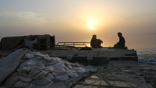 Members of the US-backed Syrian Democratic Forces (SDF) wait for a boat carrying civilians. On Saturday, several dozen civilians waited on the northern side of the lake, hours after crossing to safety, as fighters loaded up the floating bridge moored near the Jaabar Castle, a local historical site. (Delil Souleiman/AFP) Members of the US-backed Syrian Democratic Forces (SDF) wait for a boat carrying civilians. On Saturday, several dozen civilians waited on the northern side of the lake, hours after crossing to safety, as fighters loaded up the floating bridge moored near the Jaabar Castle, a local historical site. (Delil Souleiman/AFP)