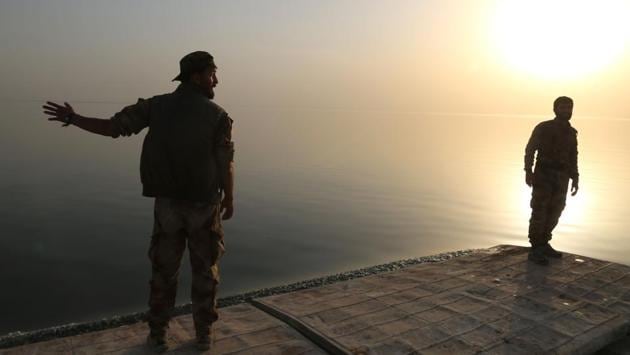 As the arrivals waited for permission to move north into SDF-held territory, fighters loaded vehicles with food and other supplies and drove them onto the makeshift ferry. (Delil Souleiman/AFP) As the arrivals waited for permission to move north into SDF-held territory, fighters loaded vehicles with food and other supplies and drove them onto the makeshift ferry. (Delil Souleiman/AFP)