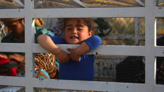 Displaced civilians are seen on the back of a pick up truck after being rescued by members of the US-backed Syrian Democratic Forces (SDF). Fighters offered civilians loaves of flat bread as they waited. The makeshift craft relies on local fishermen who have lent the SDF their boats. (Delil Souleiman/AFP) Displaced civilians are seen on the back of a pick up truck after being rescued by members of the US-backed Syrian Democratic Forces (SDF). Fighters offered civilians loaves of flat bread as they waited. The makeshift craft relies on local fishermen who have lent the SDF their boats. (Delil Souleiman/AFP)