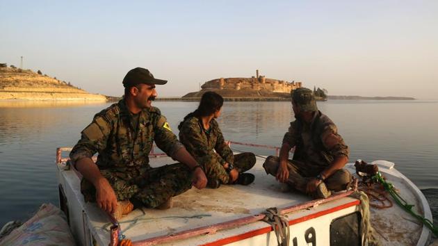 Members of the US-backed Syrian Democratic Forces (SDF) look towards the Jaabar Castle. They fish in the morning, but their boats spend the rest of the day serving as motors to get the floating bridge back and forth. (Delil Souleiman/AFP) Members of the US-backed Syrian Democratic Forces (SDF) look towards the Jaabar Castle. They fish in the morning, but their boats spend the rest of the day serving as motors to get the floating bridge back and forth. (Delil Souleiman/AFP)