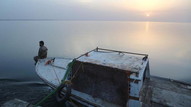 A member of the US-backed Syrian Democratic Forces (SDF) sits on the edge of a boat at the Tabqa dam. (Delil Souleiman/AFP) A member of the US-backed Syrian Democratic Forces (SDF) sits on the edge of a boat at the Tabqa dam. (Delil Souleiman/AFP)