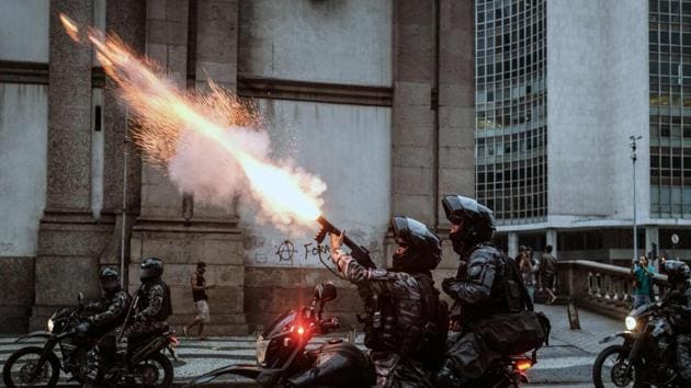 The military police shoot against protesters during the nationwide strike called by unions opposing austerity reforms in Rio de Janeiro, Brazil, on April 28, 2017. Major transportation networks schools and banks were partially shut down across much of Brazil on Friday in what protesters called a general strike against austerity reforms in Latin America's biggest country. (YASUYOSHI CHIBA / AFP)