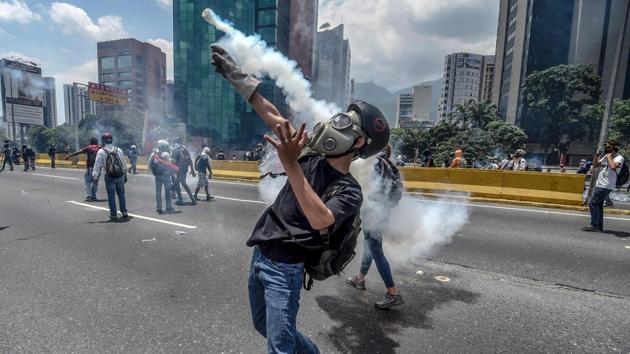 Opposition activists clash with riot police during a protest march in Caracas on April 26, 2017. Protesters in Venezuela plan a high-risk march against President Maduro Wednesday, sparking fears of fresh violence after demonstrations that have left 26 dead in the crisis-wracked country. (JUAN BARRETO / AFP)