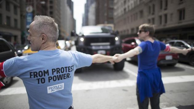 Protest marshals lock arms to stop traffic during "100 Days of Failure" protest and march, in New York. (Mary Altaffer/AP)