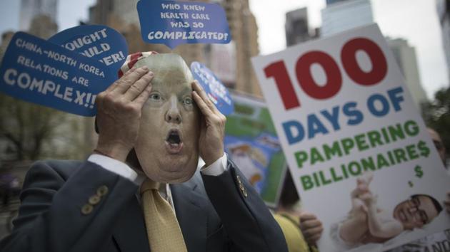 A demonstrator wears a Donald Trump mask during a "100 Days of Failure" protest and march. (Mary Altaffer/AP)