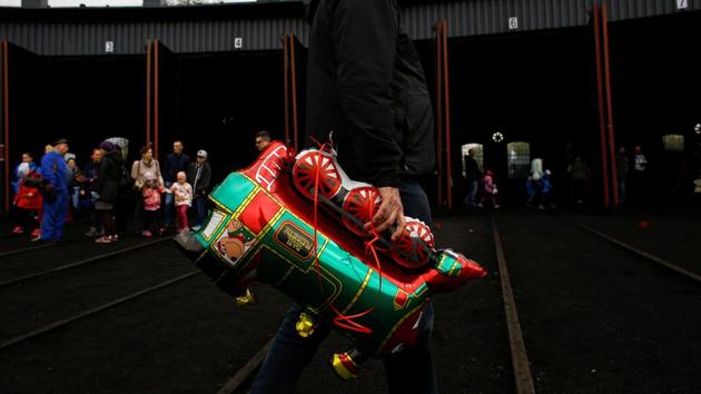 A man holds balloon in the shape of locomotive after the Parade. (Kacper Pempel /REUTERS)
