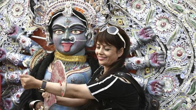 A visitor taking a picture with the idol of Goddess kali. (Raj K Raj/HT PHOTO) 
