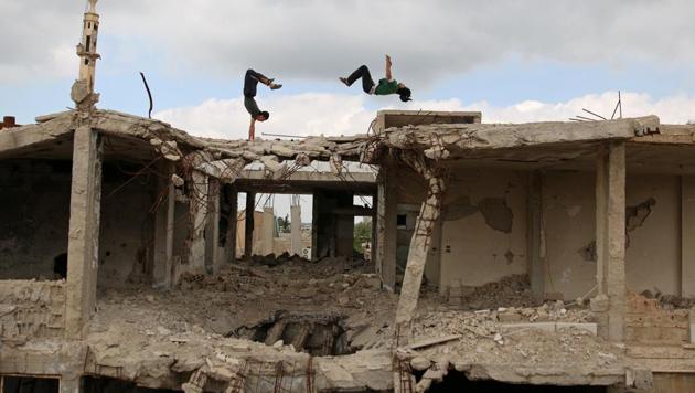 Parkour coach Ibrahim al-Kadiri (R), 19, and Muhannad al-Kadiri, 18, demonstrate their Parkour skills amid damaged buildings in the rebel-held city of Inkhil, west of Deraa, Syria, April 7, 2017. Ibrahim discovered Parkour in Jordan, where he had fled to escape the war. Back in his home town since 2015, he now leads a group of 15 practitioners. (Alaa Al-Faqir / Reuters) Parkour coach Ibrahim al-Kadiri (R), 19, and Muhannad al-Kadiri, 18, demonstrate their Parkour skills amid damaged buildings in the rebel-held city of Inkhil, west of Deraa, Syria, April 7, 2017. Ibrahim discovered Parkour in Jordan, where he had fled to escape the war. Back in his home town since 2015, he now leads a group of 15 practitioners. (Alaa Al-Faqir / Reuters)