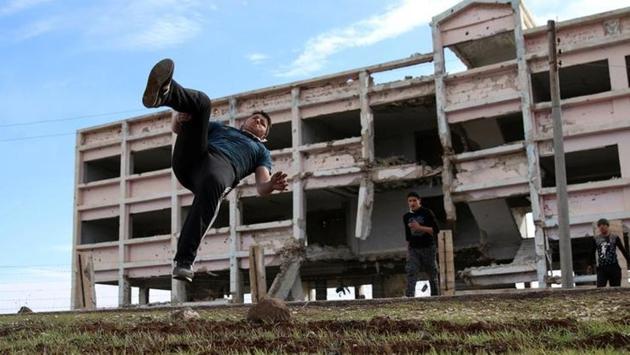 Ibrahim Eid, 16, demonstrates his Parkour skills in front of damaged building. (Alaa Al-Faqir / Reuters) Ibrahim Eid, 16, demonstrates his Parkour skills in front of damaged building. (Alaa Al-Faqir / Reuters)