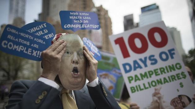 A demonstrator wears a Donald Trump mask during a ‘100 Days of Failure’ protest and march, April 29, New York(AP)