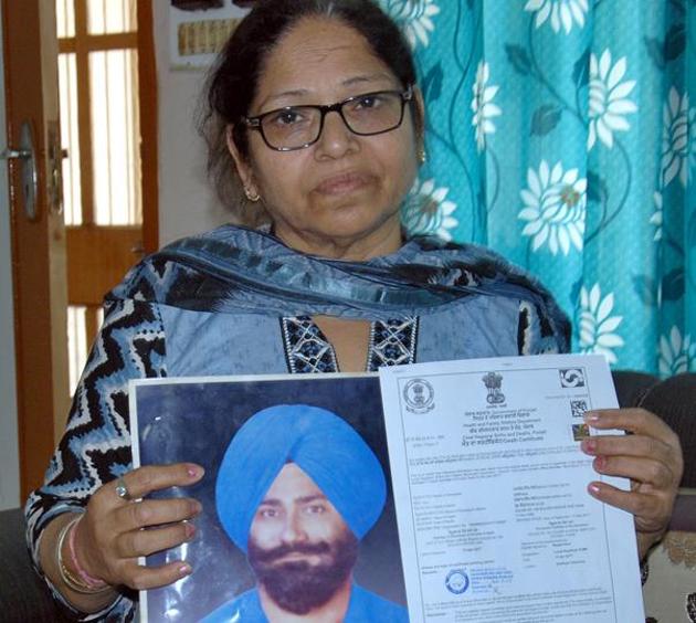 Paramjit Kaur, wife Manjit Singh Sethi showing his photo and death certificate at her home in Amritsar.(HT Photo)
