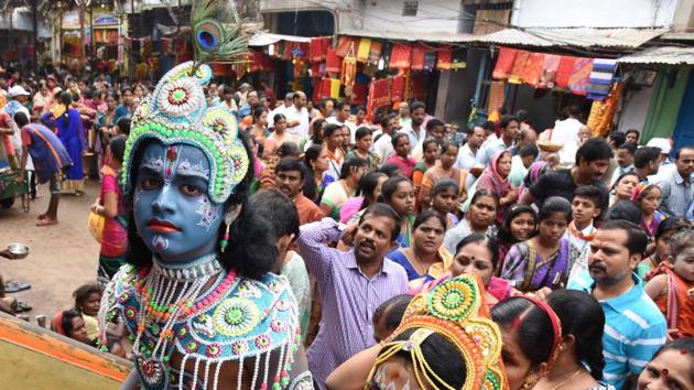 A portrait of a young boy dressed up as Lord Krishna at a pandal.