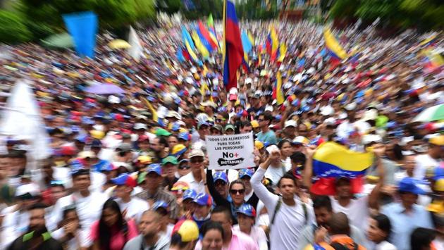 Venezuelan opposition activists takes part in a march against President Nicolas Maduro, in Caracas . Security forces in riot vans blocked off central Caracas Monday as Venezuela braced for pro- and anti-government May Day protests one month after a wave of deadly political unrest erupted. (RONALDO SCHEMIDT / AFP)