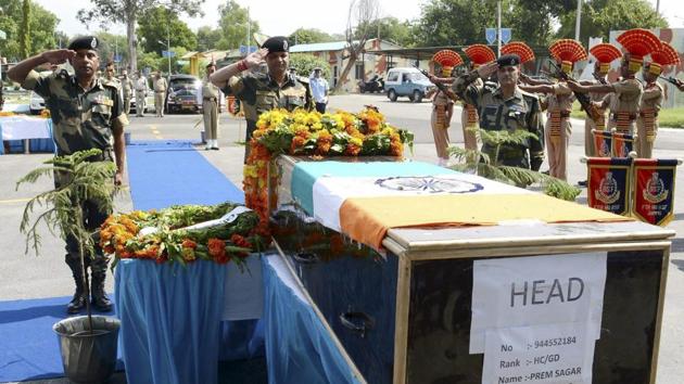 Assistant director general of Border Security Force's Western Command Kamal Nayan Choubey (C) pays his respects to head constable Prem Sagar during a wreath laying ceremony in Jammu on Tuesday. (PTI Photo) Assistant director general of Border Security Force's Western Command Kamal Nayan Choubey (C) pays his respects to head constable Prem Sagar during a wreath laying ceremony in Jammu on Tuesday. (PTI Photo)