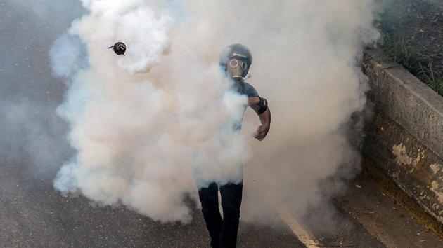An opposition activist clashes with the riot police . (FEDERICO PARRA / AFP)