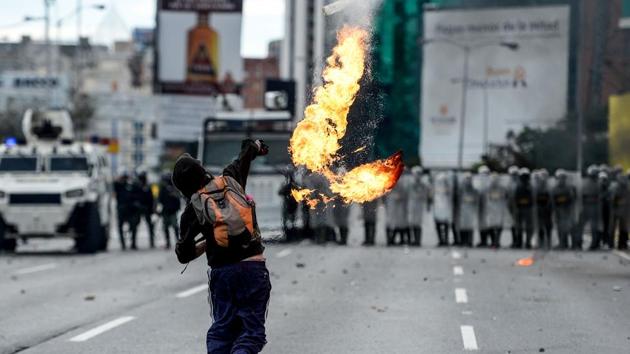 An opposition activist throws a molotov cocktail at the police. (Federico PARRA / AFP)