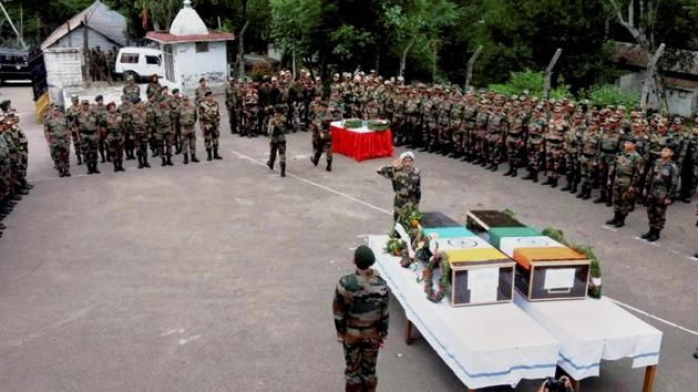 A senior army official pays respects to martyrs naib subedar Paramjit Singh and head constable Prem Sagar of BSF, on Tuesday in Jammu.(PTI Photo)