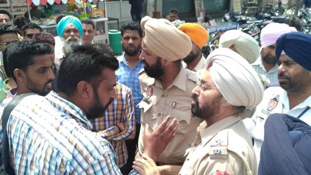 People and policemen arguing over the ‘slapping’ incident in Sangrur on Tuesday.(HT photo)
