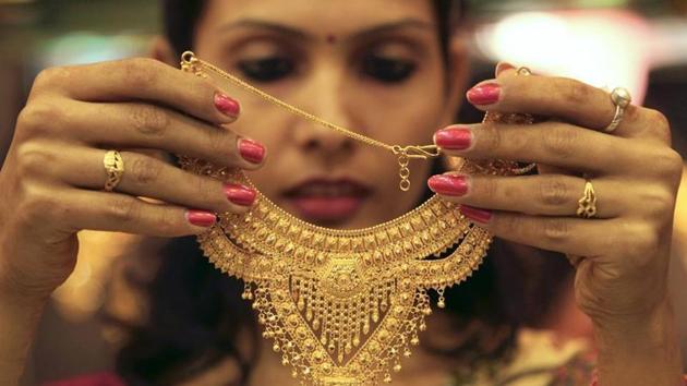 A salesgirl shows a gold necklace to customers at a jewellery showroom in the northern Indian city of Chandigarh. (Reuters photo) A salesgirl shows a gold necklace to customers at a jewellery showroom in the northern Indian city of Chandigarh. (Reuters photo)