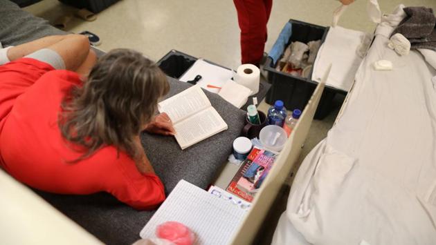 A woman lies on a bed in a dormitory. About 240 of the detainees at Adelanto are women (Lucy Nicholson /Reuters)