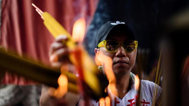 A devotee lights joss sticks in a temple. Pipers, drummers and lion dancers accompanied by a cacophony of cymbals filled the streets of the normally sleepy island of Cheung Chau, as part of the annual “bun festival” parade. (Anthony Wallace/AFP) 
