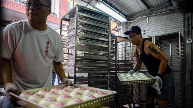 Along the parade route shoppers bought bags of the sweet buns at the heart of the celebrations. (Anthony Wallace/AFP) 