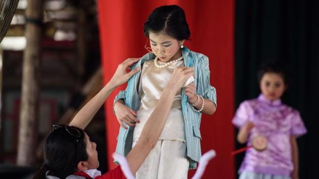 A young girl (C) dressed as chief executive-elect Carrie Lam prepares to take part in a parade. The festivities today revolve around Cheung Chau’s Pak Tai temple and attract visitors from all over Hong Kong and abroad. (Anthony Wallace/AFP) 