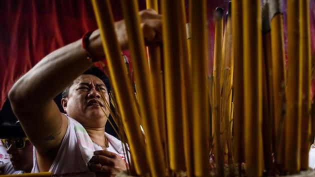 A devotee places his joss stick in an urn at a temple during the annual Cheung Chau bun festival. (Anthony Wallace/AFP) 