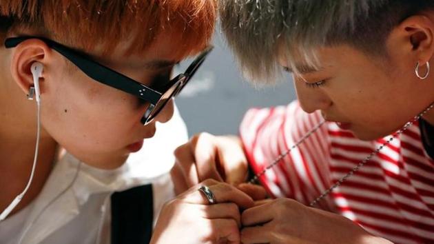 Members of China's all-girl ‘boyband’ FFC-Acrush fix a necklace before a rehearsal. (Thomas Peter / Reuters) Members of China's all-girl ‘boyband’ FFC-Acrush fix a necklace before a rehearsal. (Thomas Peter / Reuters)