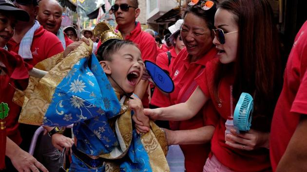 A boy in traditional Chinese costume reacts to heat during the Bun Festival parade. (Bobby Yip/REUTERS) 