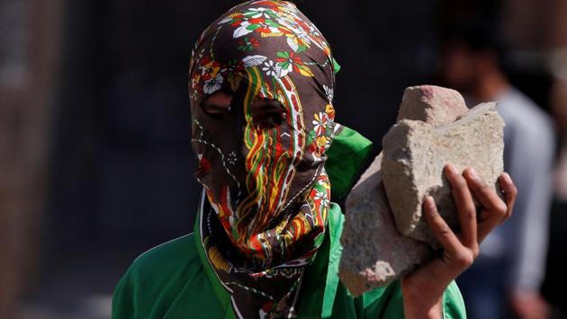 A masked protester holds stones during a protest in Srinagar.(REUTERS)