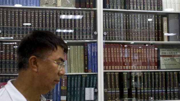 A Chinese man walks by a cabinets displaying Chinese encyclopedias at a book store in Beijing on Thursday.(AP) A Chinese man walks by a cabinets displaying Chinese encyclopedias at a book store in Beijing on Thursday.(AP)