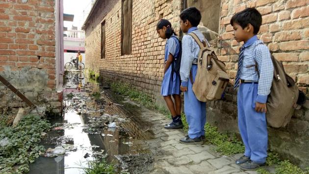 School children walk beside overflowing sewerage water through narrow streets of Uttar Pradesh’s Gonda, which has been declared as the dirtiest city in the country.(Deepak Gupta/ HT)