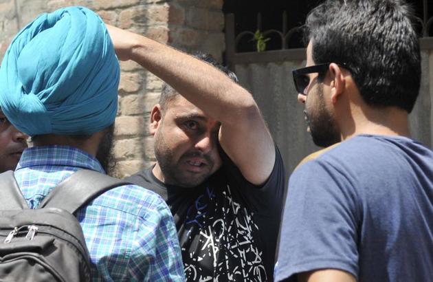 Factory owners in shock at Cheema Chowk in Ludhiana on Friday, May 5. Fire broke out at two factories and five godowns in the afternoon. Eight fire tenders were pressed into service. (Gurminder Singh/HT)