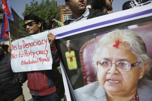 Supporters of Bibeksheel Nepali party hold a portrait of the Supreme Court Chief Justice Sushila Karki during a protest against her suspension in Kathmandu, Nepal, on Monday.(AP)