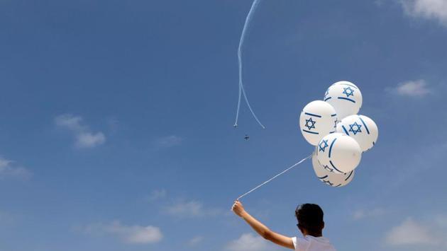 A boy watches the Israeli Air Force Aerobatic team fly over the Mediterranean Sea during an aerial show as part of the celebrations for Israel's Independence Day marking the 69th anniversary of the creation of the state in Tel Aviv. (Ammar Awad/REUTERS)
