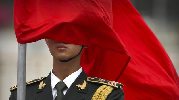 A Chinese honour guard member stands at attention as his ceremonial flag blows across his face before a welcome ceremony for Danish Prime Minister Lars Lokke Rasmussen at the Great Hall of the People in Beijing. (Mark Schiefelbein/AP)