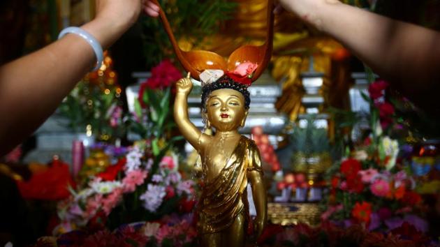 People pour water onto a Buddha statue during a celebration event for Buddha's birthday in Sanya, Hainan province, China. (REUTERS)