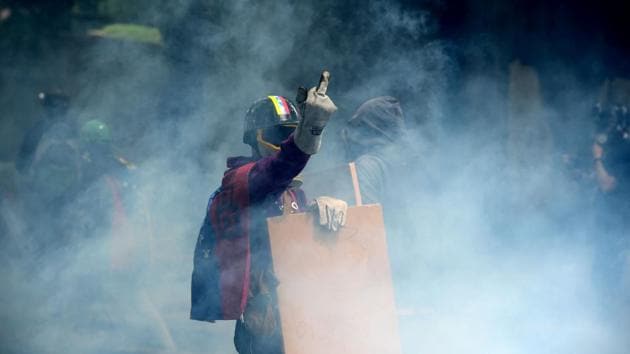 An opposition activist gestures during a march against President Nicolas Maduro, in Caracas. Security forces in riot vans blocked off central Caracas Monday as Venezuela braced for pro- and anti-government May Day protests one month after a wave of deadly political unrest erupted. (Ronaldo Schemidt/AFP)