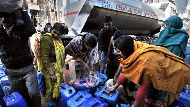 Residents fill their containers with water from a municipal tanker in New Delhi.(HT Photo)