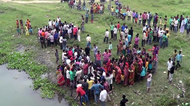 An anxious crowd near the river from where the body of the victim was recovered.(HT photo)