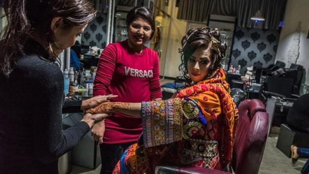 In this photograph taken on March 23, 2017, an Afghan bride dressed in a traditional wedding gown sits as a beautician applies moisturiser ahead of her wedding party at a beauty parlour in Kabul. (AFP) In this photograph taken on March 23, 2017, an Afghan bride dressed in a traditional wedding gown sits as a beautician applies moisturiser ahead of her wedding party at a beauty parlour in Kabul. (AFP)