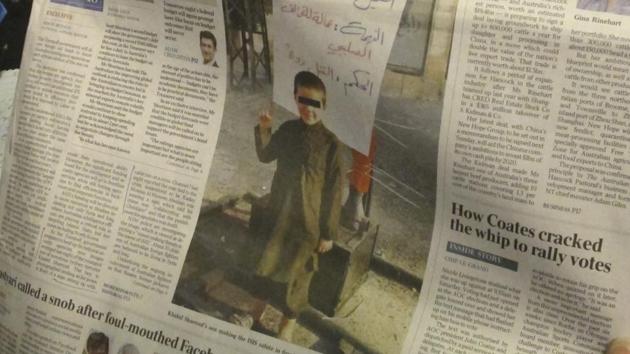 This photo published on the front page of the Monday, May 9, 2017, edition of "The Australian" newspaper shows says a 6-year-old Australian boy making an Islamic State movement salute in front of a human body hanging from a cross. (AP Photo) This photo published on the front page of the Monday, May 9, 2017, edition of "The Australian" newspaper shows says a 6-year-old Australian boy making an Islamic State movement salute in front of a human body hanging from a cross. (AP Photo)