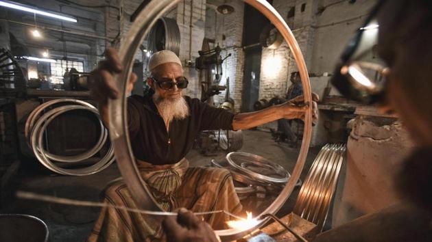 66 year-old Karimuddin who has worked here for 35 years helps put a drum through a manufacturing process. (Ravi Choudhary/HT PHOTO) 66 year-old Karimuddin who has worked here for 35 years helps put a drum through a manufacturing process. (Ravi Choudhary/HT PHOTO)