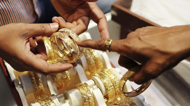 n employee shows gold bangles to a customer at a jewellery showroom on the occasion of Dhanteras, a Hindu festival associated with Lakshmi, the goddess of wealth, at a market in Mumbai November 1, 2013. A scarcity of gold and high prices are pushing Indians to look to silver or diamond jewellery as alternative gifts this festive season, adding to the gloom in the gold trade after government measures to restrict imports. REUTERS/Danish Siddiqui (INDIA - Tags: BUSINESS RELIGION) - RTX14WFQ(Reuters photo)