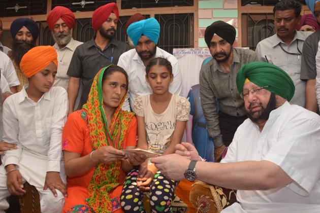 Chief minister Capt Amarinder Singh with the family of martyr Paramjit Singh at Vein Poin village in Tarn Taran on Sunday.(Sameer Sehgal/HT Photo)