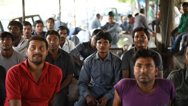 Debendra Kapri watches TV while waiting for passengers with other drivers at a taxi stand near the Airport. (Ravi Choudhary/HT PHOTO)