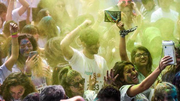 Revellers throw coloured powders in the air during the festival. (Ozan Kose/AFP)