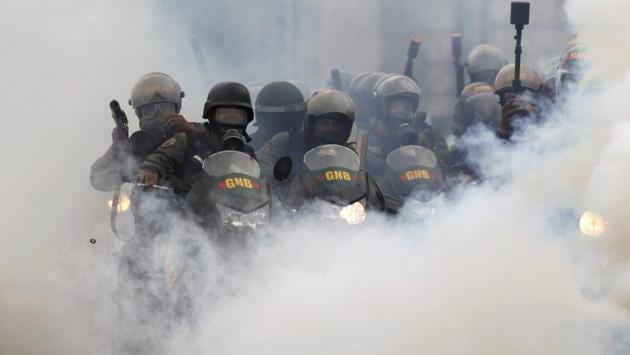 Bolivarian National Guards block students attempting to march to the Education Ministry amid tear gas in Caracas. The protest movement against President Nicolas Maduro, that has drawn masses of people into the streets nearly every day since March, has left some three dozen dead. (AP)